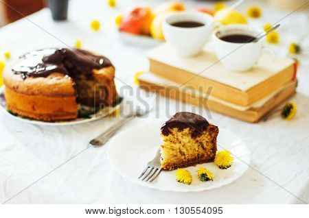 Traditional homemade chocolate cake. Rustic style and natural light. Chocolate Mud Cake on White table. Piece of chocolate cake with icing. Vanilla Cake with Chocolate Glaze.