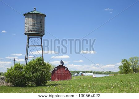 Old wooden water cistern and red barn in rural Iowa