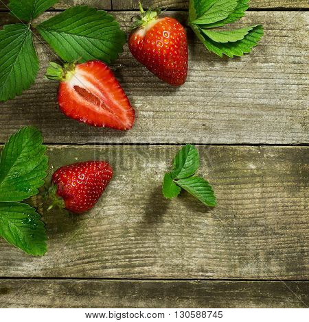 Two and a one half strawberrys on a old wooden background