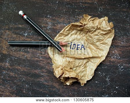 concept creased paper of idea and broken pencils on wooden table