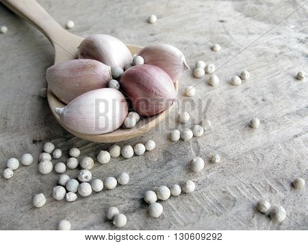white peppers with garlic on wooden spoon