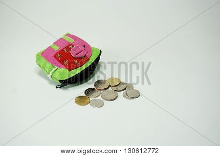 Coins falling from purse isoltaed on white background