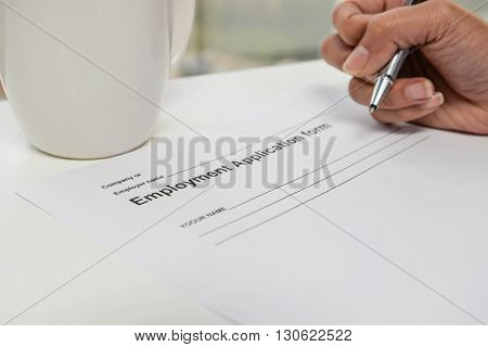 Writing Employment application form and cup of coffee