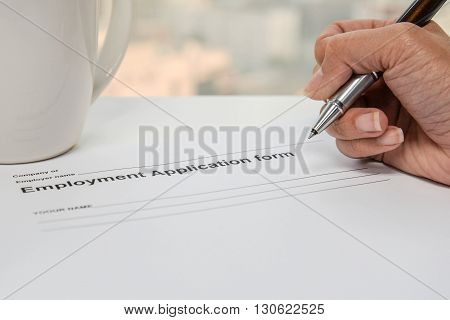 Writing Employment application form and cup of coffee