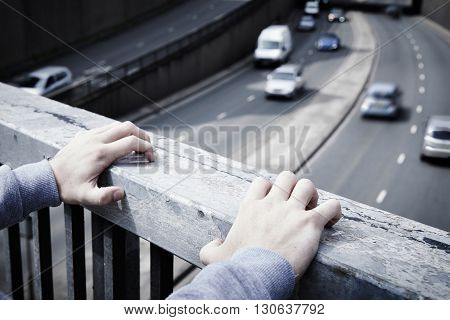 Depressed Young Man Contemplating Suicide On Road Bridge