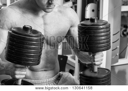 Strong man. Muscle training in the gym. Training in the gym.