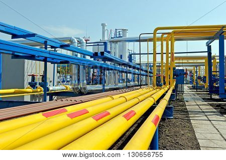Yellow gas pipes in natural gas treatment plant in bright sunny summer day