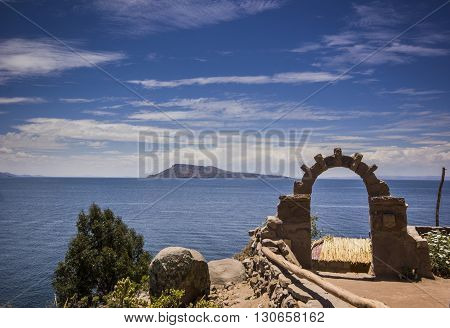 arch above titicaca lake in peru with blue sky