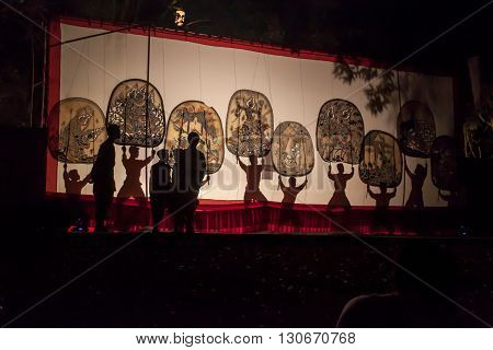 RATCHABURI THAILAND - APRIL 14 2015: The Cowskin shows a man holding a stencil pattern. Moving Cowskin the light to shadow play. The musical atmosphere and read a poem composed. In a traditional culture. There are performances every year Thailand in SONGK