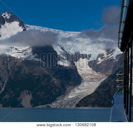 The side of a boat gives scale to a tidewater glacier.