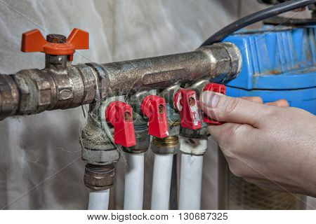 Household water supply unit distribution of domestic water supply system valves blocking access to water pipes hand turning faucet valve.