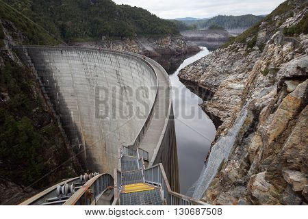 The Gordon Dam, also known as the Gordon River Dam, is a major gated double curvature concrete arch dam with a controlled spillway across the Gordon River, located in South West Tasmania, Australia
