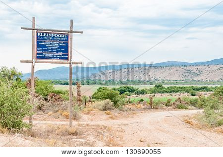 BAVIAANSKLOOF SOUTH AFRICA - MARCH 6 2016: Signboard for a farm and business in the Baviaanskloof (baboon valley). The road and farm land are visible