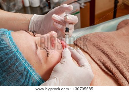 Cosmetic injection in the spa salon. Beautician makes injection into the patient's face. Beauty injections mesotherapy revitalization cosmetic medicine injection - the concept of rejuvenation.