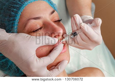 Cosmetic injection in the spa salon. Beautician makes injection into the patient's face. Beauty injections mesotherapy revitalization cosmetic medicine injection - the concept of rejuvenation.