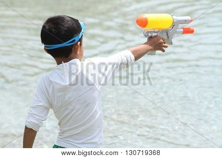 Japanese boy playing with water gun (first grade at elementary school)