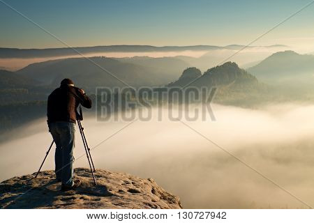 Professional On Cliff. Nature Photographer Takes Photos With Mirror Camera On Rock. Dreamy Fogy Land