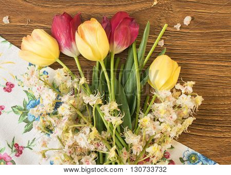 Beautiful Flowers Tulips And Chestnuts On A Wooden Table