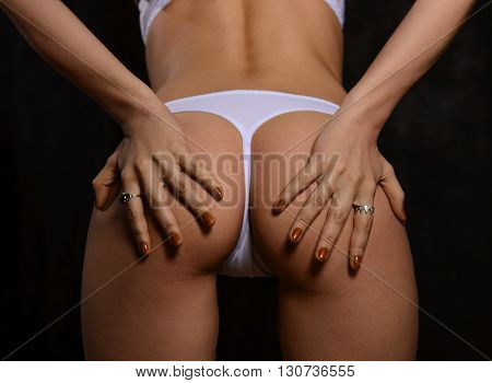 Women's Booty in white panties on a black background of the body part