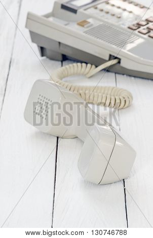 telephone with handset down on the side on white wooden backgroundsoft focus.