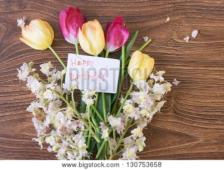 Beautiful Flowers Tulips And Chestnuts On A Wooden Table