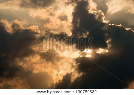Sun shining and casting rays trough a beautiful and slowly moving cloudscape