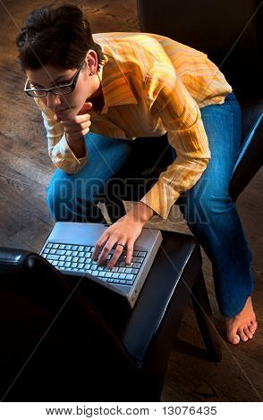 Junge Frauen arbeitet an einem Laptop-Computer in der häuslichen Umgebung.