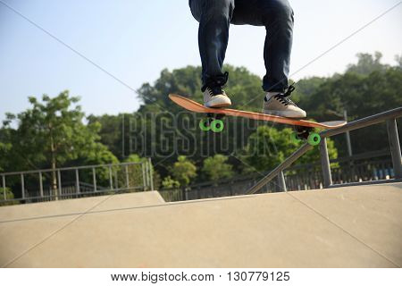 young woman skateboarder practice ollie at skatepark