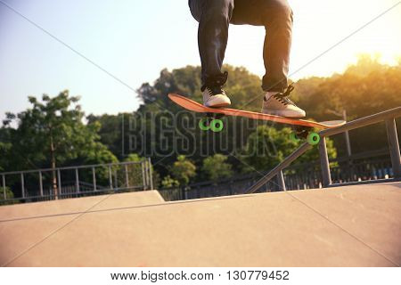 young woman skateboarder practice ollie at skatepark