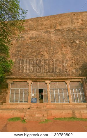 Chettinad India - October 15 2013: Chithannavasal Cave Jain Temple is hewn into a huge rock. A screen fills a pillared gate in front of the cave opening; the only temple item visible from outside. Rock wall in photo.