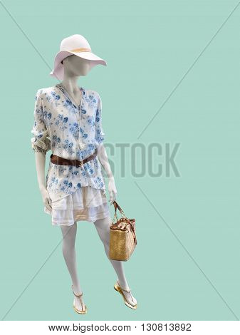 Full length female mannequin dressed in fashionable clothes Isolated on green background. No brand names or copyright objects.