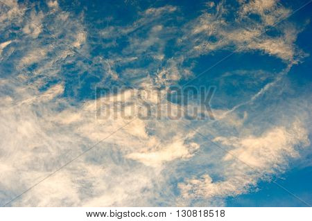 Thin clouds colored by the sun with a blue sky background