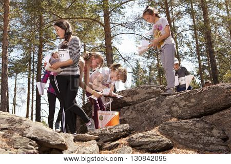 RUSSIA, ULAN-UDE - MAY 22, 2016: Russian Azimut - 2016. Orienteering competition is held annually in the Buryatia region. People at at control point at orienteering course.