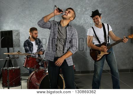 Musicians playing musical instruments and singing songs in a studio