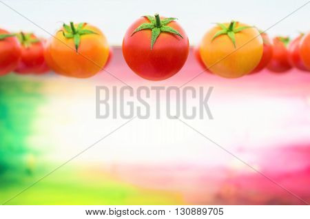 Fresh tomatoes against a colorful background with Italian's flag colors