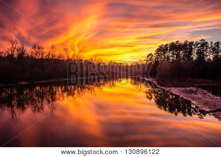 an orange sunset reflection over thw lake