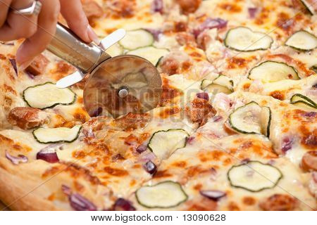 Fette di pizza mano taglio HumanD con taglierina di pizza.