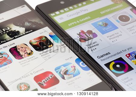 Melbourne, Australia - May 23, 2016: Close-up view of Google Play Store on Android smartphone and Apple's App Store on iPhone. Both stores allow users to download app, music, movies and TV shows.