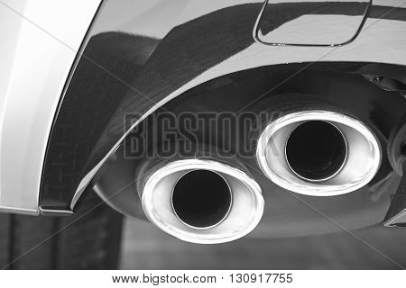 Double car exhaust pipe detail in black and white. Pollution. Horizontal