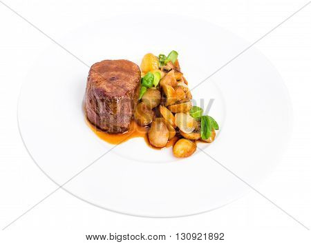 Delicious beef steak in demiglas sauce with vegetable garnish. Isolated on a white background.