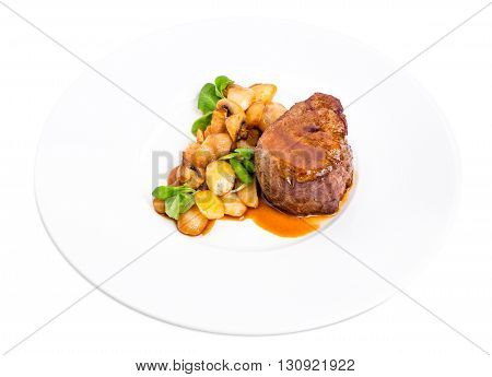 Delicious beef steak in demiglas sauce with vegetable garnish. Isolated on a white background.