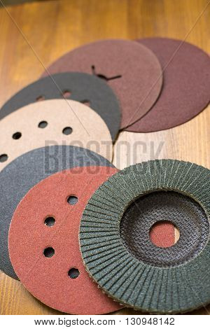 Abrasive disks for metal and stonewood grinding cutting. Set of abrasive materials on wooden background vertical view.