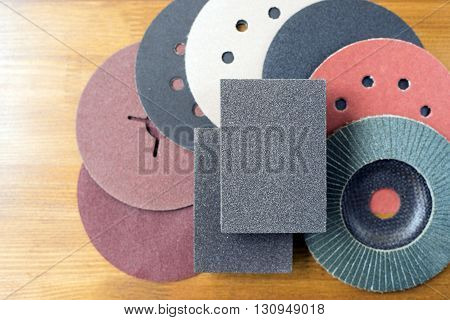 Abrasive disks for metal and stonewood grinding cutting. Set of abrasive materials on wooden background vertical view.