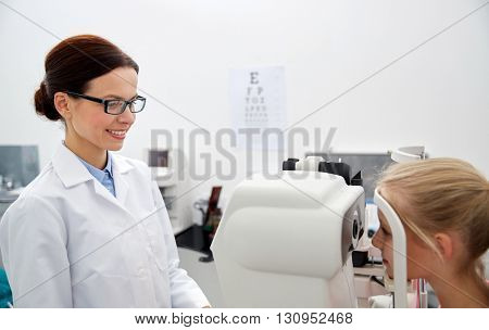 health care, medicine, people, eyesight and technology concept - optometrist with non contact tonometer checking patient intraocular pressure at eye clinic or optics store
