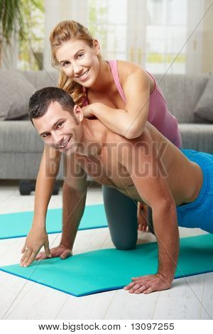 Junges Paar Push-up-Übung zu Hause im Wohnzimmer zu tun.