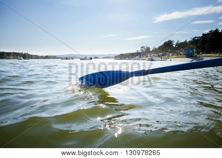 Boat paddle on water of lake, rowing