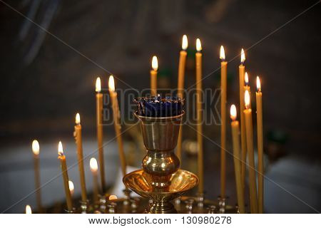Lighting yellow candles in Orthodox Church, Russia