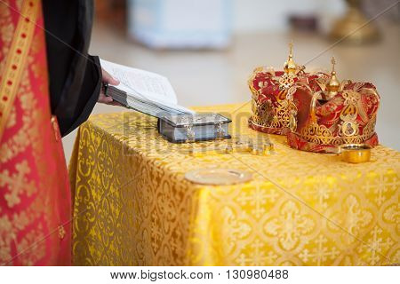 Orthodox Church wedding paraphernalia on table - cross, bible and crowns