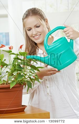 Happy young Woman Bewässerung Anlage mit Beregnung kann lächelnd.