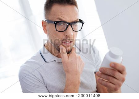 Biohacking Medication. Meditative Progressive Uncertain Man Posing On Light Background While Putting